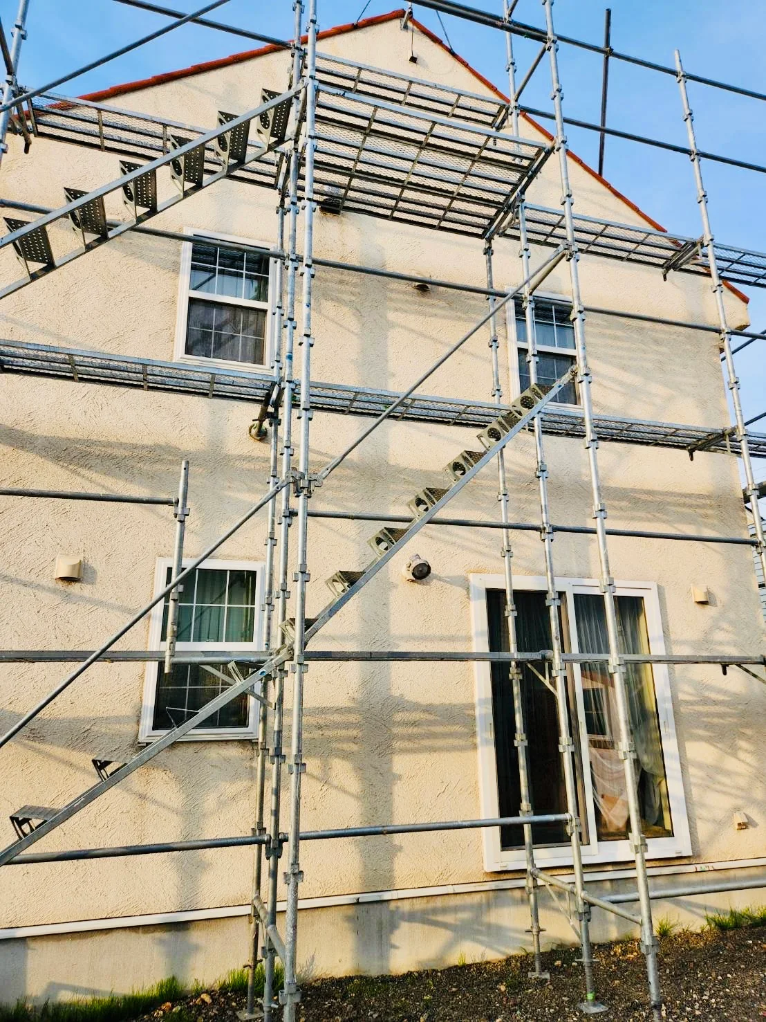 住宅外壁まわりに足場を設置した施工中の様子